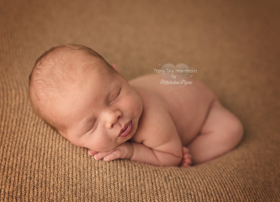 newborn dreng sovende på brunt tæppe
