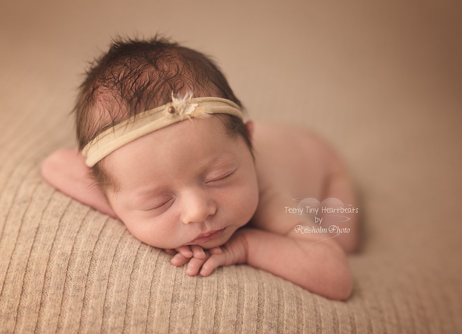 nyfødtfoto af pige på brunt tæppe med hænderne under hovedet hos fotograf Teeny Tiny Heartbeats