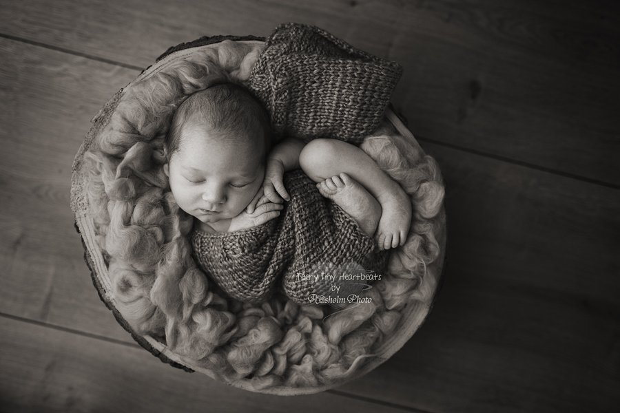 foto taget af fotograf Teeny Tiny Heartbeats af nyfødt baby liggende på ryggen i træskål - sort hvid