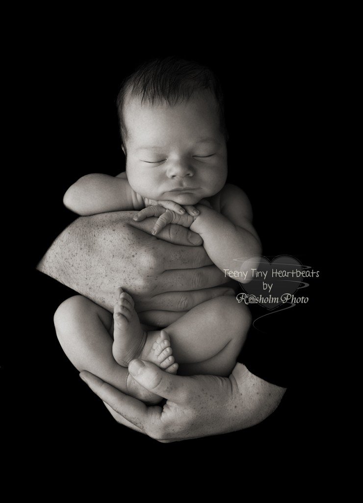smilende billede af nyfødt i fars arme i sort hvid